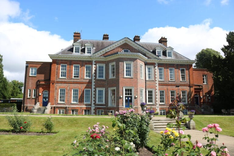 Historic red brick mansion with garden view.