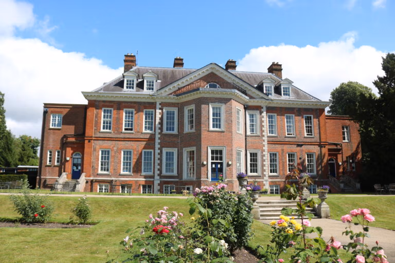 Historic red brick mansion with garden view.